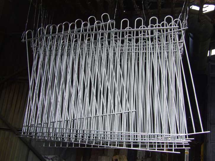 mild steel sections of bow top fencing after being removed from molten zinc bath as part of the hot dip galvanizing process to B.S. EN. ISO 1461 (2009)