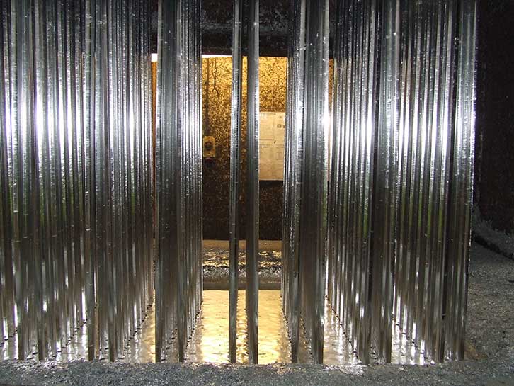 mild steel sections of Palisade fencing after being removed from molten zinc bath as part of the hot dip galvanizing process to B.S. EN. ISO 1461 (2009)