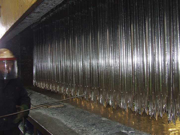 mild steel sections of Palisade fencing after being removed from molten zinc bath as part of the hot dip galvanizing process to B.S. EN. ISO 1461 (2009)